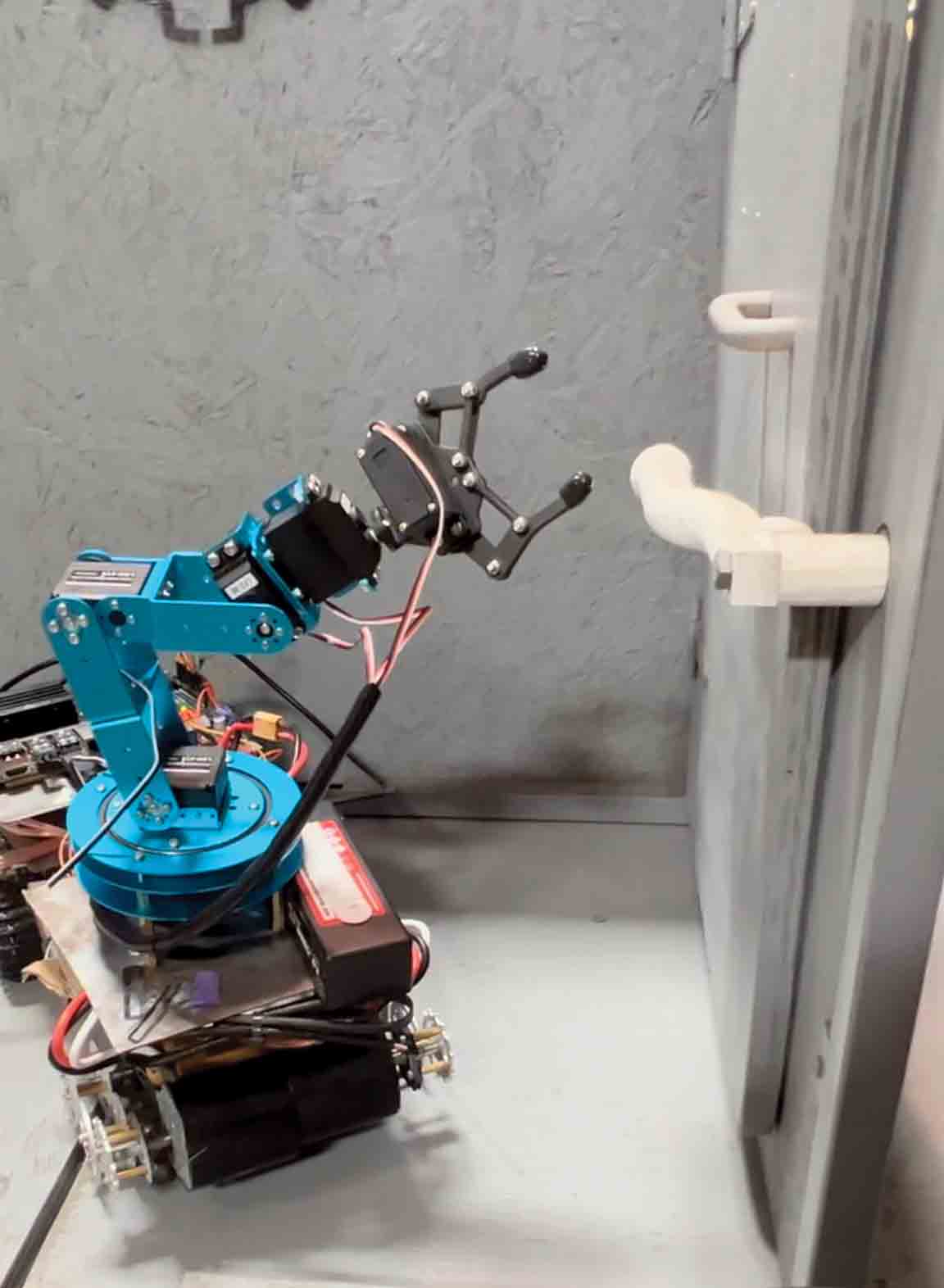 The robot arm in action, moving to grab a pipe.
